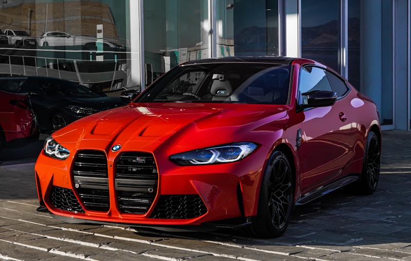 Red BMW M4 performance coupe outside a showroom
