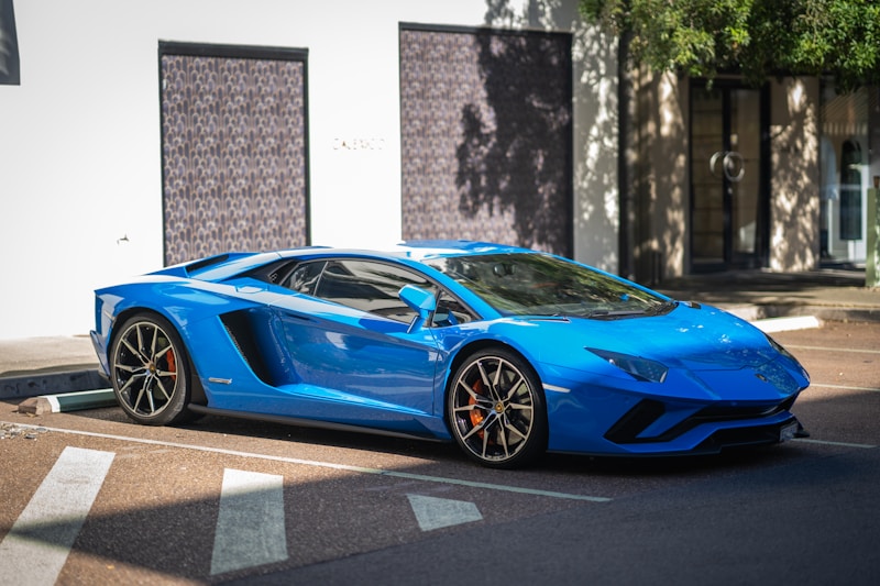 Blue Lamborghini Aventador parked curbside