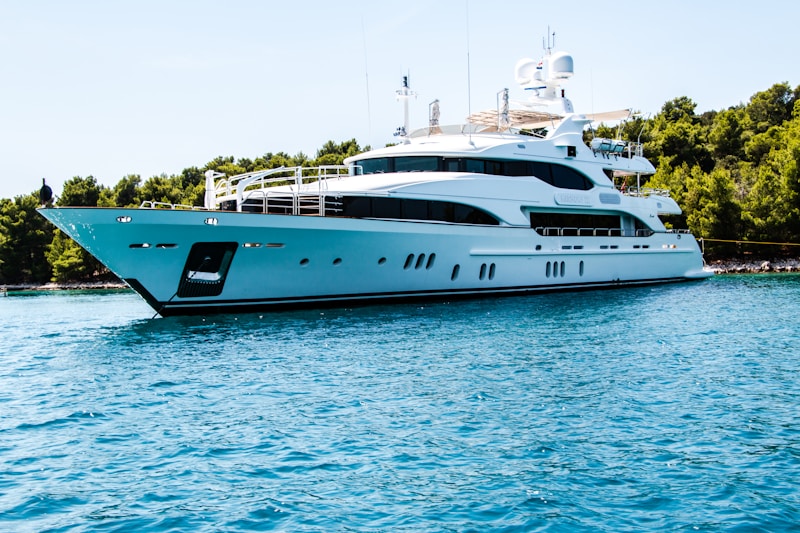 White superyacht anchored in clear blue water