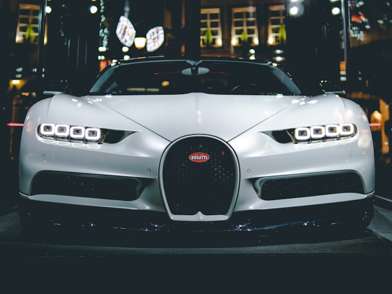 Silver Bugatti Chiron displayed under city lights